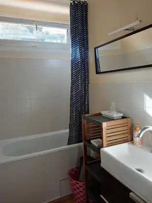 a bathroom with a sink and a tub and a mirror at Appartement Lumineux Vue Panoramique in Ajaccio
