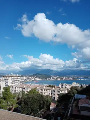 a view of a city with buildings and the water at Appartement Lumineux Vue Panoramique in Ajaccio