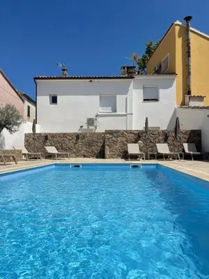 a large swimming pool in front of a building at Hôtel Restaurant La Caravelle in Sari Solenzara