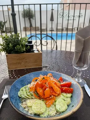 a plate of food with vegetables on a table at Hôtel Restaurant La Caravelle in Sari Solenzara