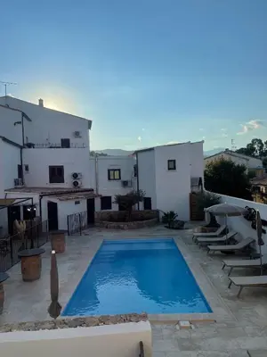 a swimming pool in front of a house at Hôtel Restaurant La Caravelle in Sari Solenzara