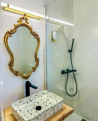 a bathroom with a shower with a sink and a mirror at Hôtel Restaurant La Caravelle in Sari Solenzara