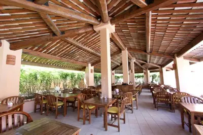 a restaurant with tables and chairs and a wooden ceiling at Résidence Sognu Di Mare - Plage in Linguizzetta