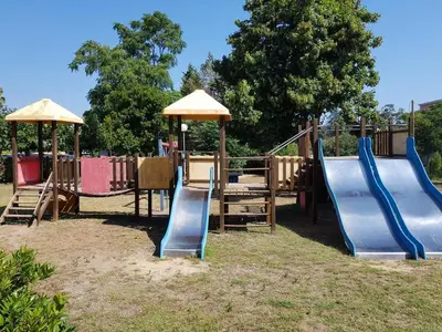 a playground with slides and umbrellas in a park at Résidence Sognu Di Mare - Plage in Linguizzetta