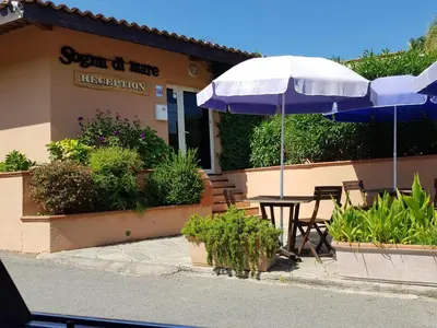 a restaurant with a table and an umbrella at Résidence Sognu Di Mare - Plage in Linguizzetta