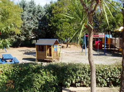 a small playground with a small house in a park at Résidence Sognu Di Mare - Plage in Linguizzetta