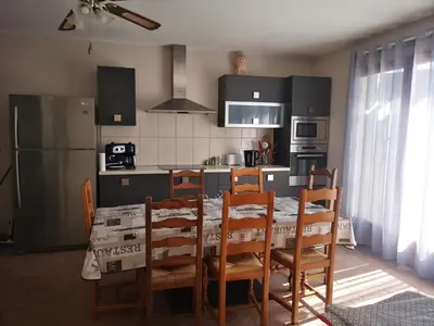 a kitchen with a table with chairs and a refrigerator at E Cabane in Rottani