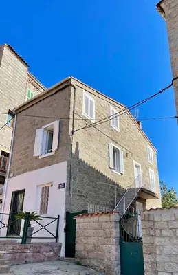 a large brick building with a staircase on it at Duplex en plein centre in Propriano