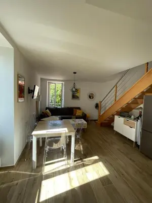 a living room with a table and a staircase at Duplex en plein centre in Propriano