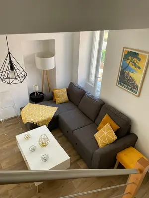 a living room with a couch and a table at Duplex en plein centre in Propriano