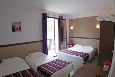 a hotel room with two beds and a balcony at Brise de Mer in Porto Ota
