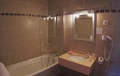 a bathroom with a sink and a tub and a shower at Brise de Mer in Porto Ota