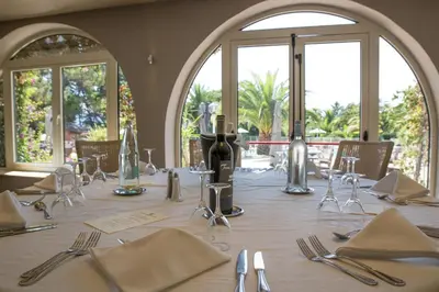 a long table with silverware and napkins on it at Hôtel Campo Dell'oro in Ajaccio
