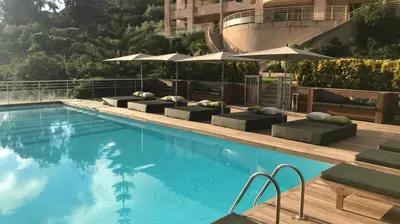 a large swimming pool with lounge chairs and umbrellas at Hôtel et Résidence Costa Rossa in Porto Ota