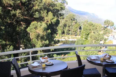 two tables and chairs on a balcony with a view at Hôtel et Résidence Costa Rossa in Porto Ota