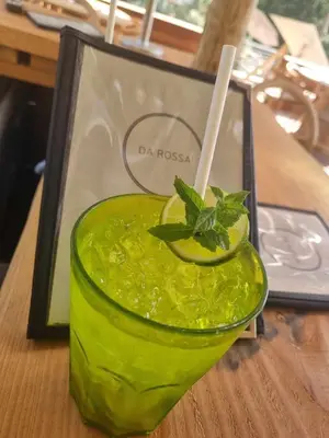 a green drink in a glass with a mint garnishment at Hôtel et Résidence Costa Rossa in Porto Ota