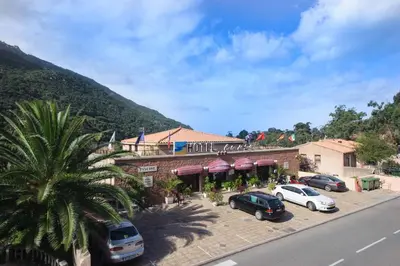 a hotel with cars parked in a parking lot at Hotel et Résidence Cala di sole in Porto Ota