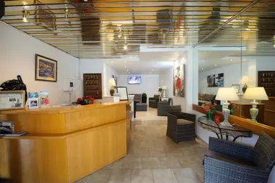 a salon with a waiting room with chairs and a counter at Hotel et Résidence Cala di sole in Porto Ota