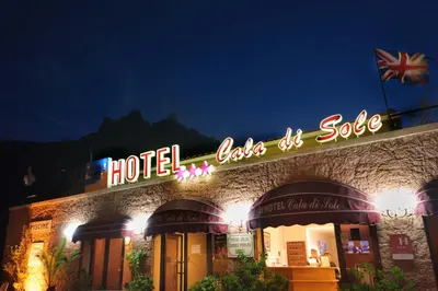 a hotel sign on the side of a building at night at Hotel et Résidence Cala di sole in Porto Ota