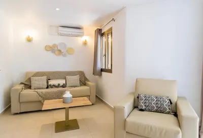 a living room with a couch and a chair at Résidence Stella di Mare in Sainte-Lucie de Porto-Vecchio
