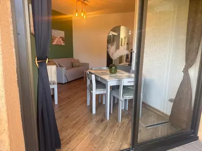 a dining room with a table and a mirror at Appartement n 79 Moriani plage in Santa-Lucia-di-Moriani