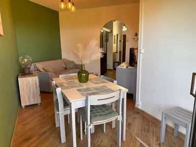 a dining room with a table and chairs and a couch at Appartement n 79 Moriani plage in Santa-Lucia-di-Moriani