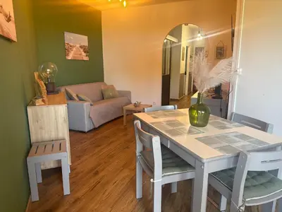a living room with a table and chairs and a couch at Appartement n 79 Moriani plage in Santa-Lucia-di-Moriani