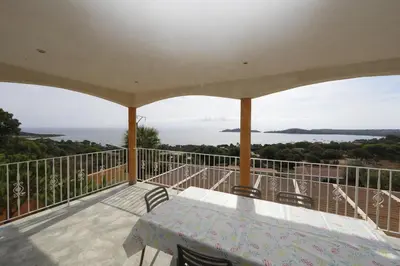 a patio with a table and chairs on a balcony at Residence Monte Cristo in Sainte-Lucie de Porto-Vecchio