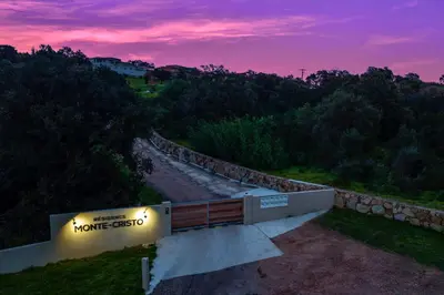 a park bench on a hill with a sunset at Residence Monte Cristo in Sainte-Lucie de Porto-Vecchio