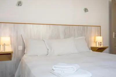 a white bed with two towels on top of it at Residence Monte Cristo in Sainte-Lucie de Porto-Vecchio