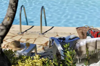 a table with a hat sitting next to a pool at U Cantu di i Cardellini in Porto-Vecchio