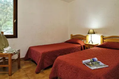 a hotel room with two beds and a window at U Cantu di i Cardellini in Porto-Vecchio