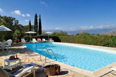 a swimming pool with chairs and umbrellas in a yard at U Cantu di i Cardellini in Porto-Vecchio