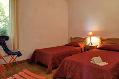 a hotel room with two beds and a window at U Cantu di i Cardellini in Porto-Vecchio