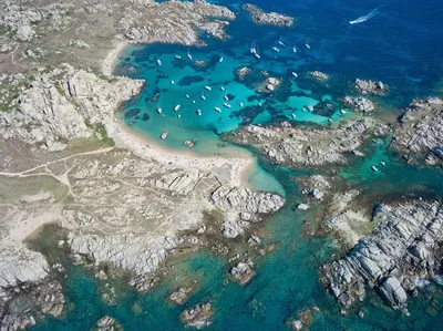 an aerial view of a beach with rocks and water at U Cantu di i Cardellini in Porto-Vecchio