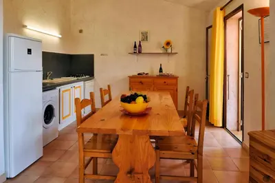 a kitchen with a wooden table with a bowl of fruit on it at U Cantu di i Cardellini in Porto-Vecchio