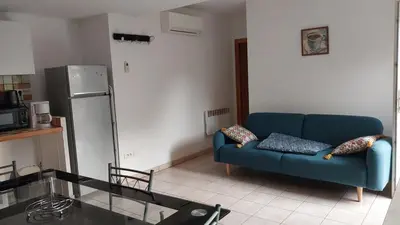 a living room with a blue couch and a refrigerator at Casapiana in Porto-Vecchio