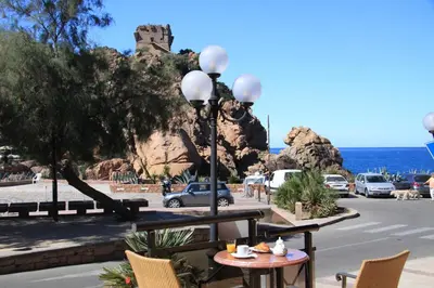 a table and chairs with a view of the ocean at Hôtel & Résidence Le Subrini in Porto Ota