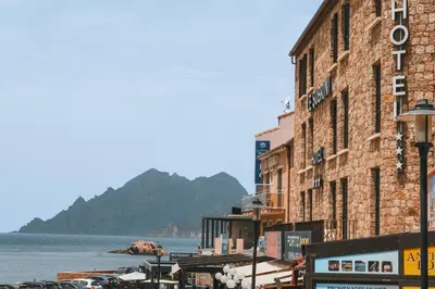 a large brick building next to a body of water at Hôtel & Résidence Le Subrini in Porto Ota