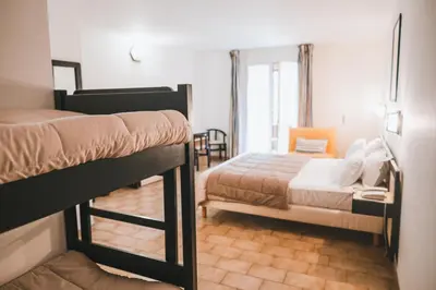 a bedroom with two bunk beds in a room at Hôtel & Résidence Le Subrini in Porto Ota