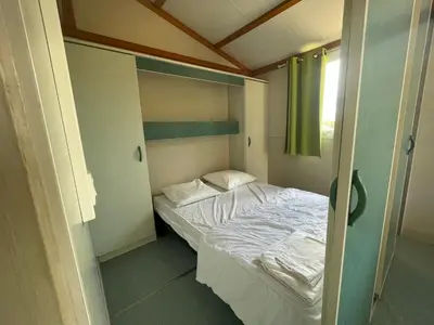 a small bed in a small room with a window at Camping Trinité in Bonifacio