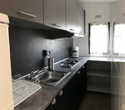 a kitchen with a sink and a stove at Camping Trinité in Bonifacio