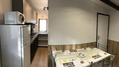 a kitchen with a refrigerator and a table in a room at Camping Trinité in Bonifacio