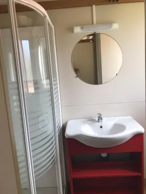 a bathroom with a sink and a mirror at Camping Trinité in Bonifacio