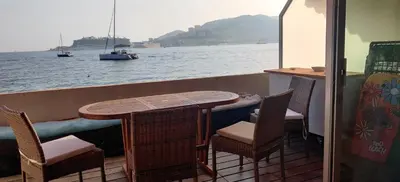 a table and chairs on the deck of a boat at Appartement sur la plage in Ajaccio