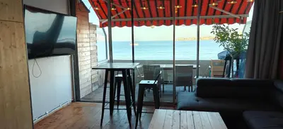 a living room with a table and a view of the ocean at Appartement sur la plage in Ajaccio
