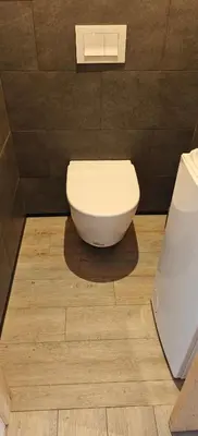 a bathroom with a toilet on a wooden floor at Appartement sur la plage in Ajaccio