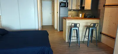 a kitchen with two bar stools in front of a counter at Appartement sur la plage in Ajaccio