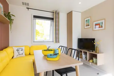 a living room with a yellow couch and a table at PetraLegna in Porto-Vecchio