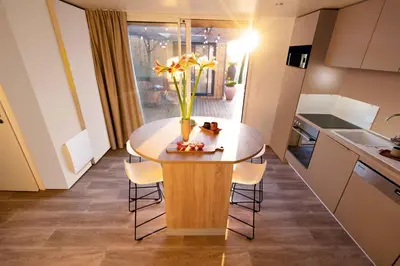 a kitchen with a table with a vase of flowers on it at PetraLegna in Porto-Vecchio